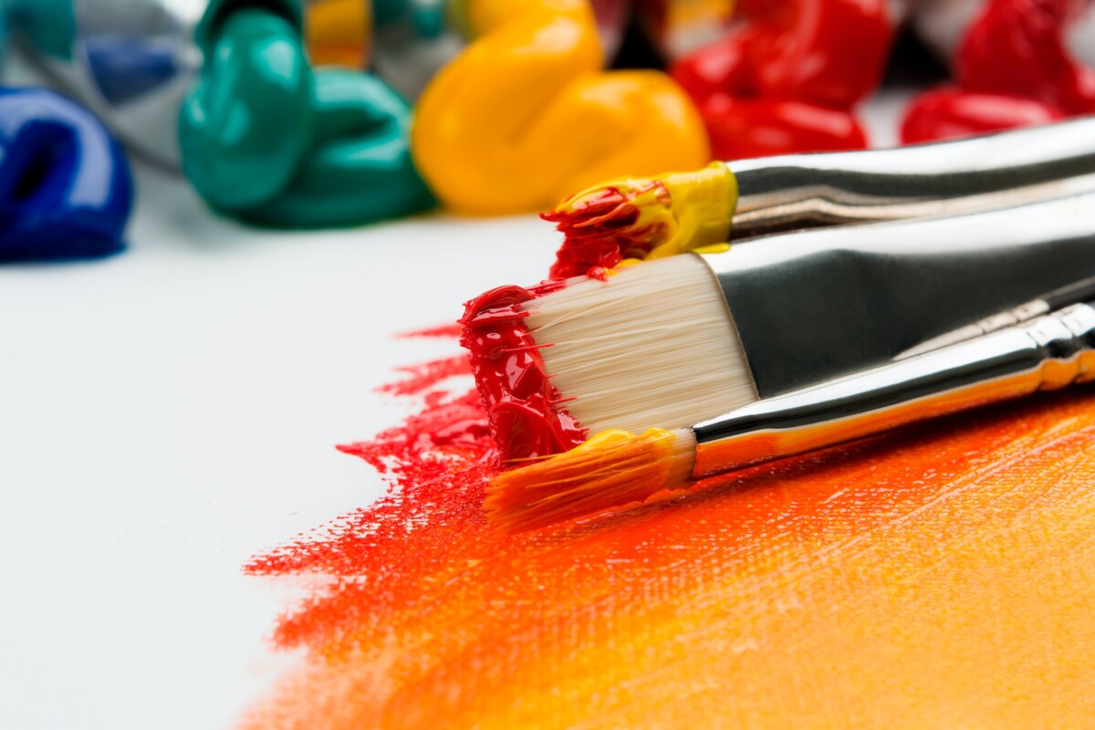 paint brushes with orange and red paints
