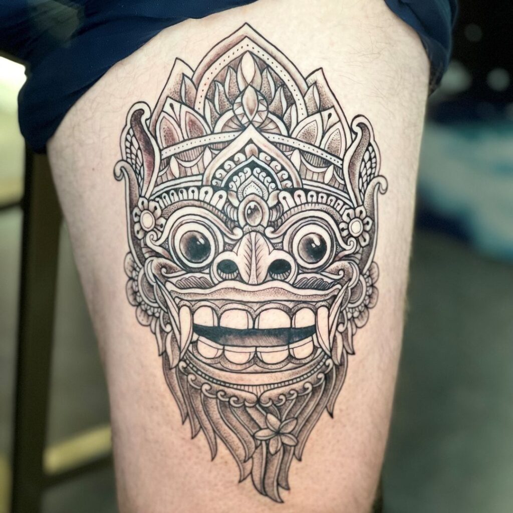 barong mask tattoo on a thigh